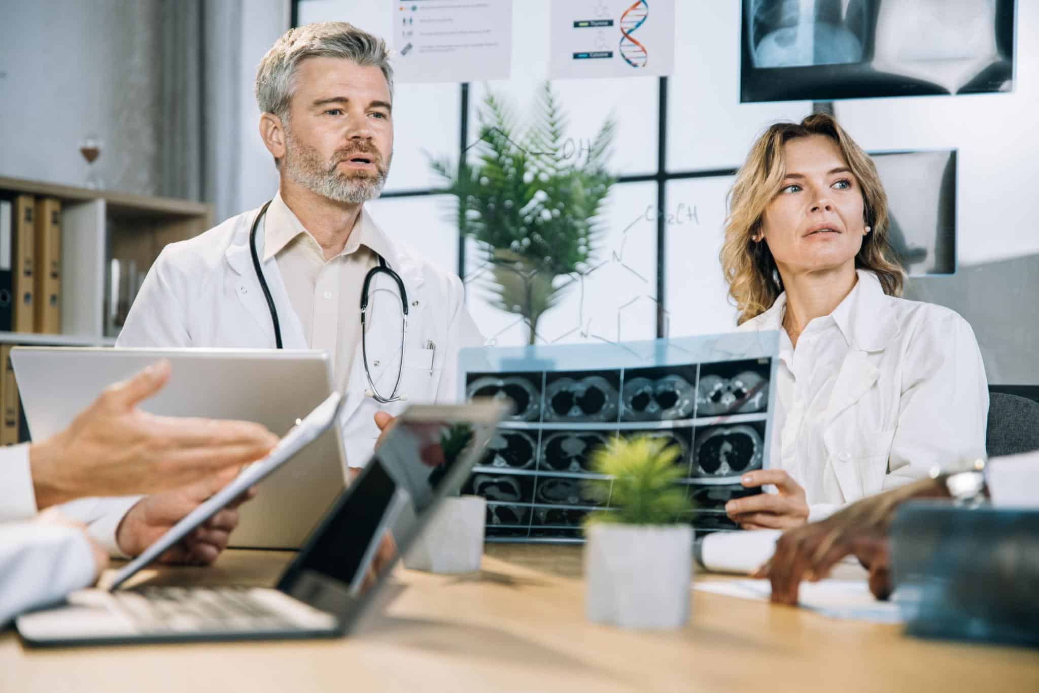 Medicii analizează investigații medicale în cadrul unui consult de oncologie